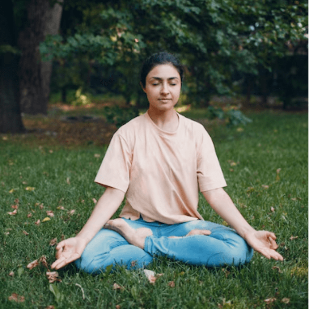 A woman shown sitting down in meditation